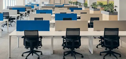 Modern open-plan office space featuring clean workstations, ergonomic chairs, and sanitized carpets provided by professional office cleaning services in Minneapolis, MN.
